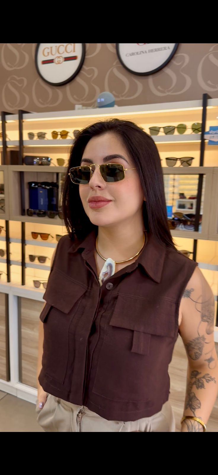 Óculos de sol com painel Gucci ao fundo na Casa Núbia